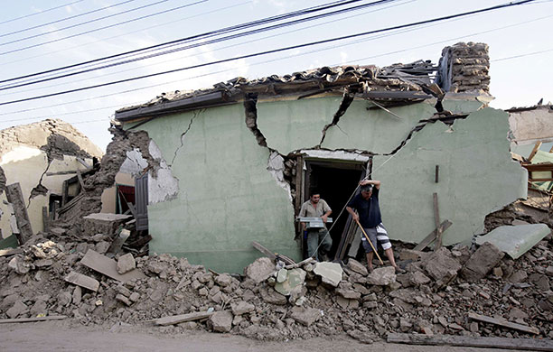 Chile after the quake: Residents recover their belongings from their home in Talca
