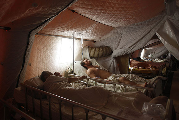 Chile after the quake: Earthquake victims lie in beds in a field hospital in Talca