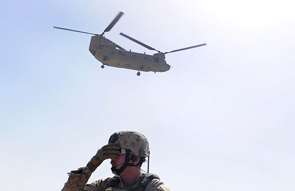 24 hours in pictures: Marjah, Afghanistan: A US Marine covers his face as a US helicopter lands