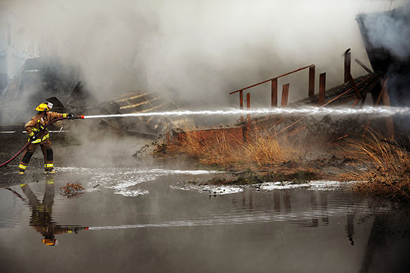 24 hours in pictures: Bellingham, Washington, USA: A firefighter hoses down buildings 