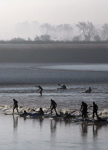 Severn Bore: Surfers enjoy the Severn Bore near Newnham along the River Severn