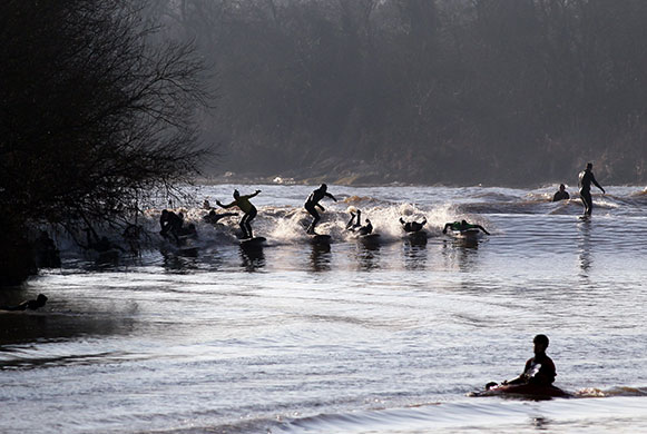 Severn Bore: Surfers enjoy the Severn Bore near Newnham along the River Severn