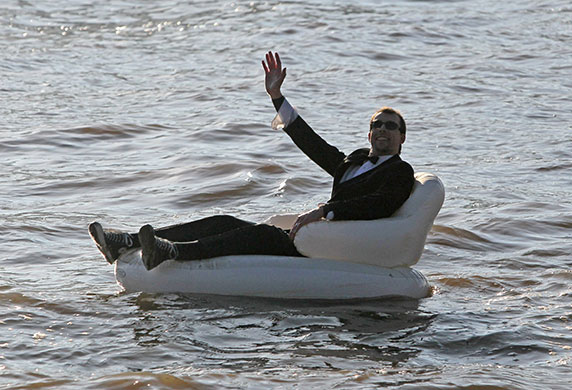 Severn Bore: A man on inflatable chair enjoys the Severn Bore along the River Severn