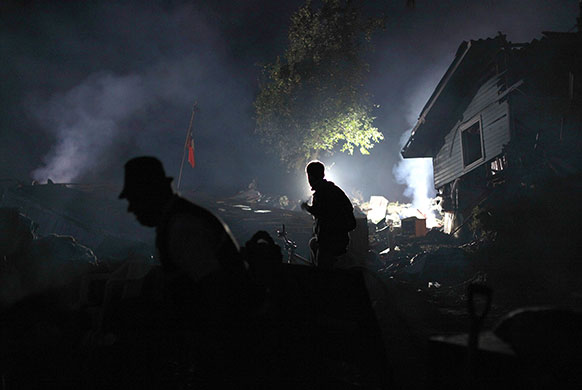 24 hours in pictures: Survivors walk in a blackout caused by a major earthquake in Constitucion