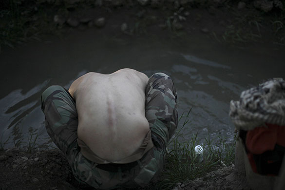 24 Hours in Pictures: A US Marine washes his head in a canal in Marjah