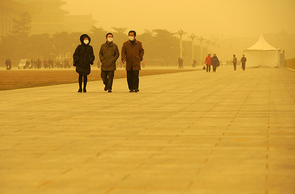 Sandstorms in China: People walk in Tiananmen Square during a sandstorm