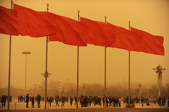 Sandstorms in China: People walk in Tiananmen square during a sandstorm
