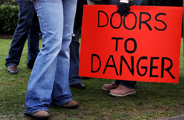 BA strike: A member of BA cabin crew holds a placard at Heathrow airport