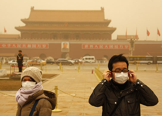 24 hours in Pictures: Chinese tourists wearing masks in a sandstorm