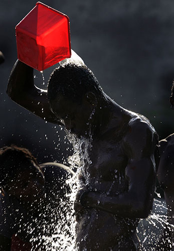 24 hours in pictures: A man bathes at an earthquake survivors camp in Port-au-Prince