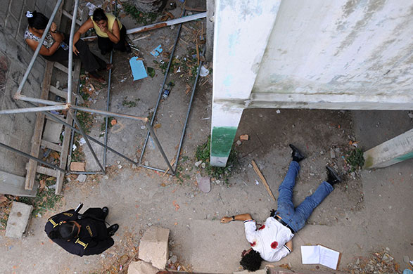 24 hours in pictures: A police woman stares at the body Tegucigalpa, Honduras