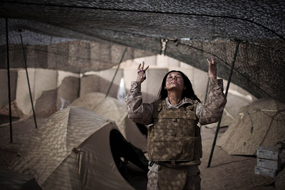 24 hours in pictures: Interpreter puts her hair up as she arranges her equipment, Afghanistan