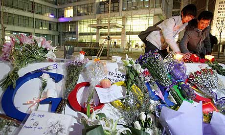 Visitors to Google's Beijing headquarters in China light candles and place flowers on a company logo
