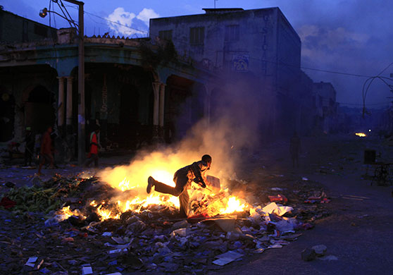 24 hours in pictures: Port-au-Prince, Haiti: A youth feeds a fire