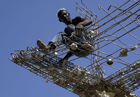 24 hours in pictures: A man works on the demolition of a collapsed building Port-au-Prince, Haiti