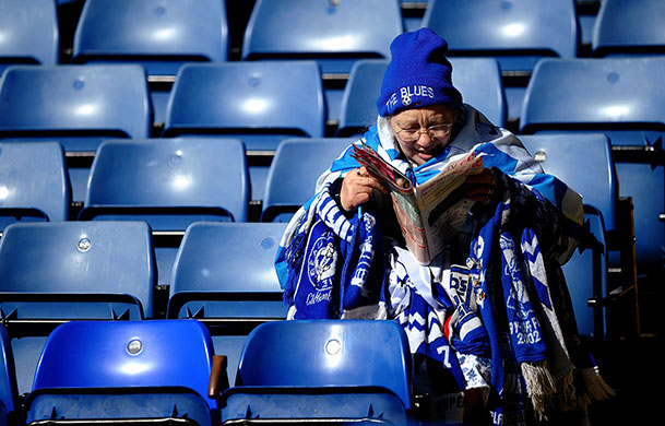 24 hours in pictures: A Birmingham Fan reads her magazine before the Barclays Premier League