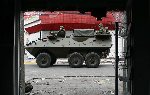 Chile security: An army armoured vehicle patrols the streets of earthquake-torn Coronel