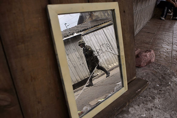 Chile security: A soldier is reflected on a mirror as he patrols in Lota, Chile