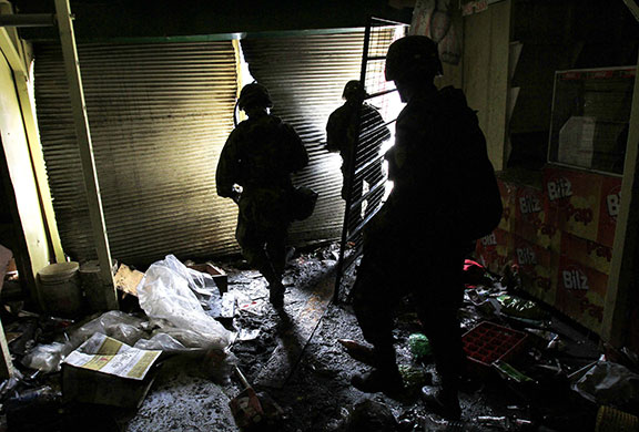 Chile security: Soldiers search for looters in a market that was already ransacked in Lota