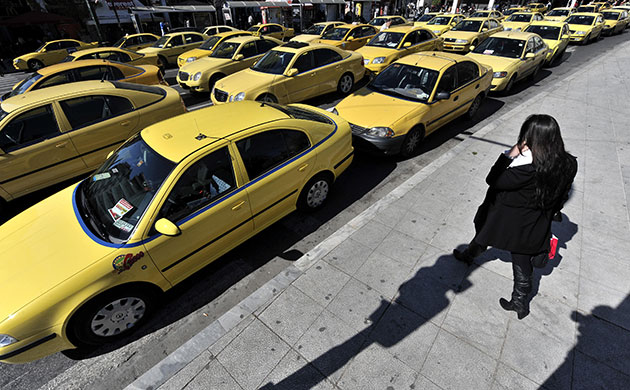 Greece protests: A woman taxis during a 48-hour taxi drivers strike, Athens, Greece