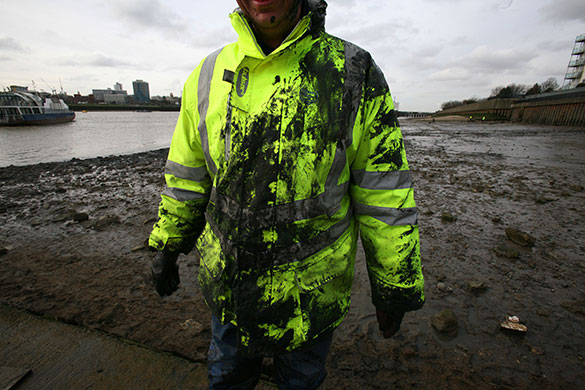 Cleaning the Thames: A volunteer covered in mud