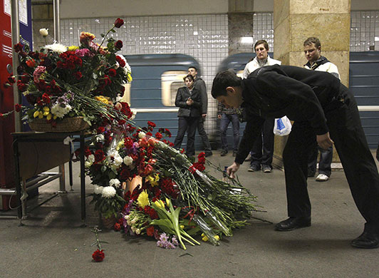 moscow bombs aftermath: A man lays flowers in memory of victims at Park Kultury station in Moscow