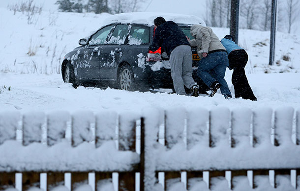 Spring snow: People push a car through the snow near Denny, Scotland