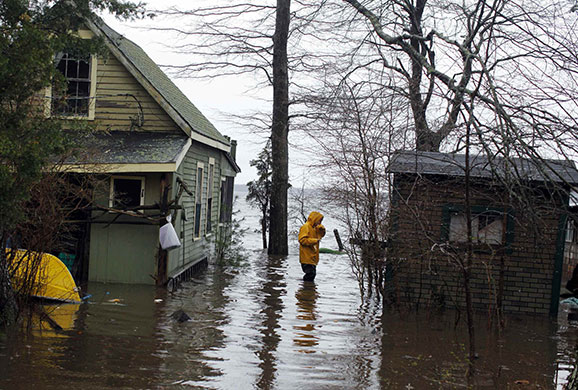 24 hours in pictures: Lakeville, US: Lee Ann Tavares checks the flood damage to her seasonal home