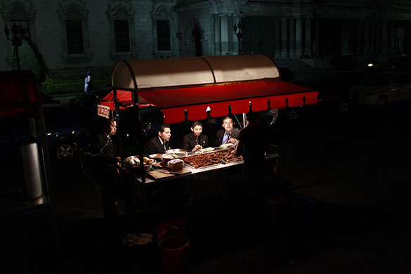 24 hours in pictures: Guatemala City, Guatemala: People eat tacos at a vendor's food stand
