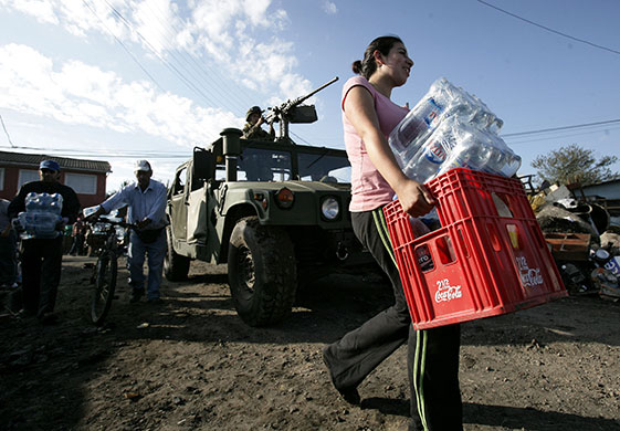 Chile Aid: Woman carries water bottles to be handed out to earthquake victims, Chile