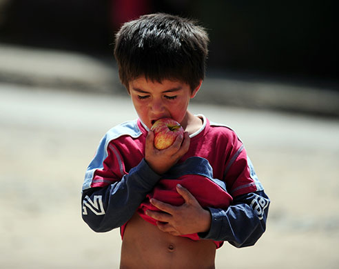 Chile Aid: A child eats an apple after food was distributed in Constitucion, Chile
