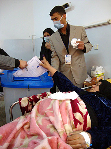 Iraq elections build up: Iraqi casts her ballot during the special voting day at a hospital