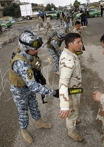Iraq elections build up: Iraqi security forces search soldiers at polling station in Mosul