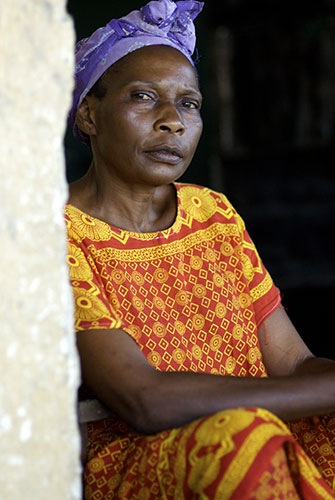 Women Health Workers: An African woman sits looking seriously to camera