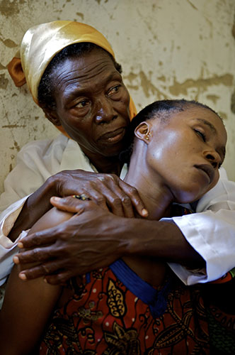 Women Health Workers: A woman healthworker holds another woman in her arms