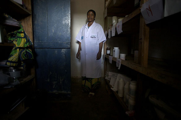 Women Health Workers: A healthworker stands amongst the drugs she's trained to administer