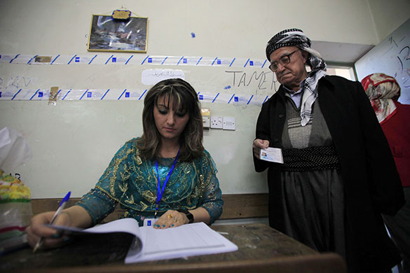 Elections in Iraq: An election worker checks a man's identification