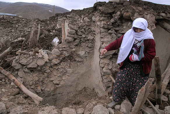 Turkey earthquake: A woman stands in front of her destroyed house in  Elazig