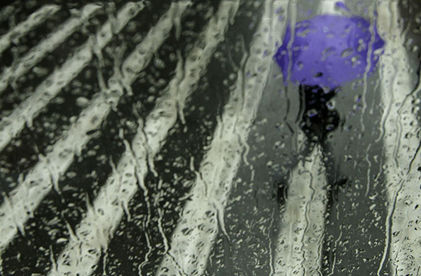 24 hours in pictures: Athens, Greece: An Athenian shelters under an umbrella