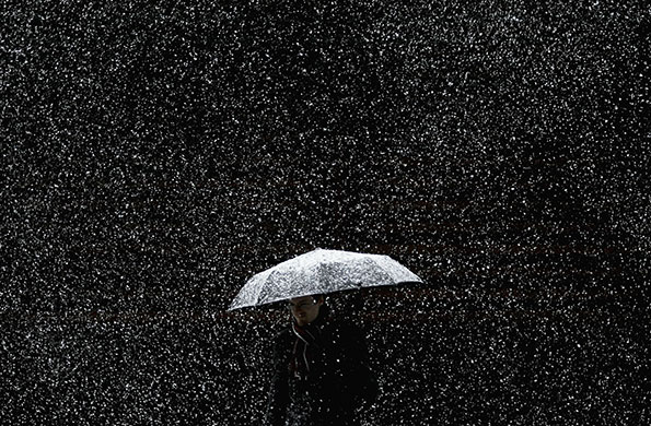 snow in barcelona: A man walks under an umbrella