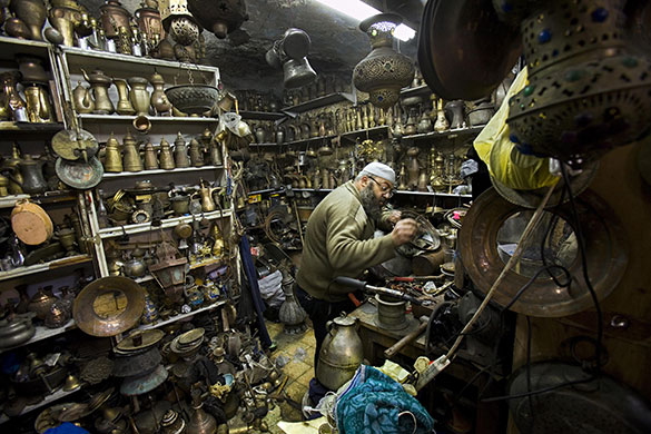 24 hours in pictures: Jerusalem: Muhammed Abdel Jawd, a Palestinian metalsmith, works in his shop