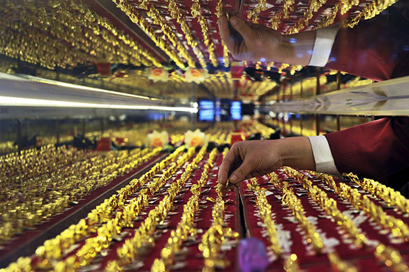 24 hours in pictures: Shenyang, China: A vendor arranges gold rings on display at a jewelery shop