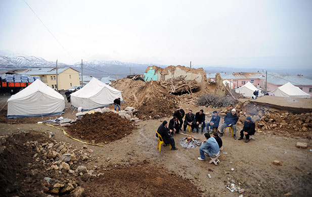 Turkey earthquake: Villagers gather around a camp fire amid debris of what used to be houses 