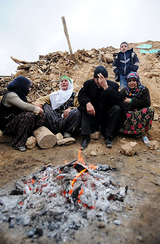 Turkey earthquake: Earthquake victims grieve as they sit around a campfire