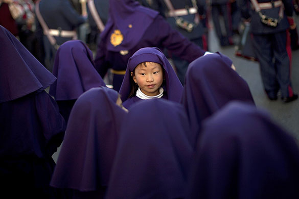 Holy week: Malaga, Spain: A young penitent takes part in the procession