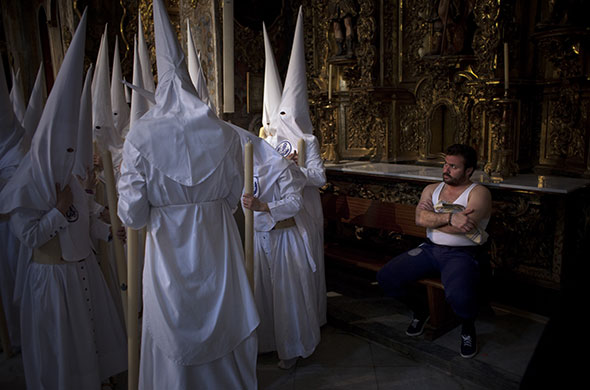 Holy week: Seville, Spain: A costalero watches as penitents wait to process