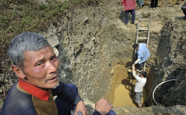 Drought in South China: Villagers dig a well to collect water at a village in Xifeng