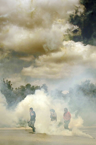 24 Hours in Pics: Protesters runs for cover amid a cloud of tear gas fired by Israeli troops