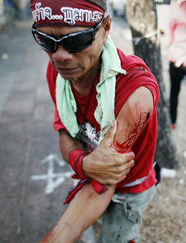 Riots in Thailand: An anti-government red shirt protester is wounded in Bangkok