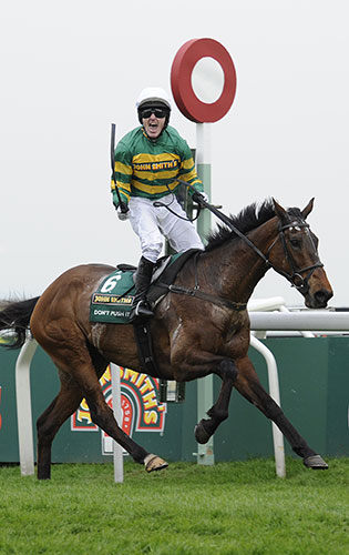 grand national: McCoy celebrates as he crosses the line to win his first National